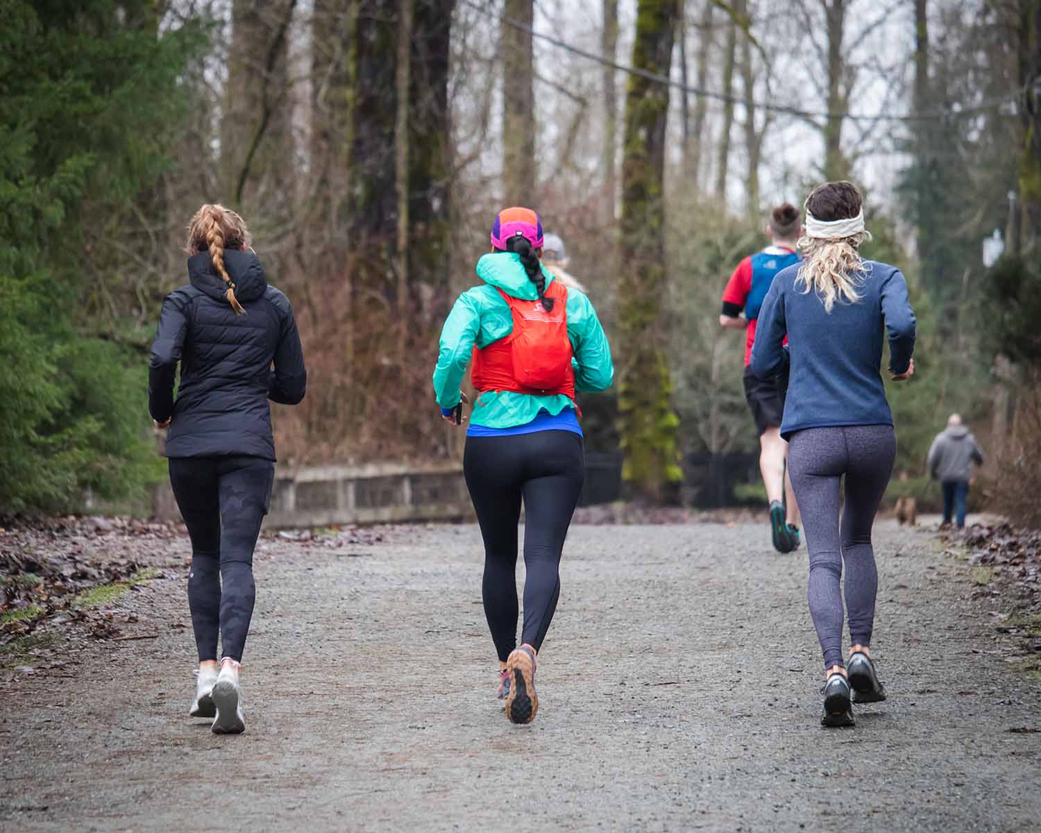 a group of people running on a gravel path